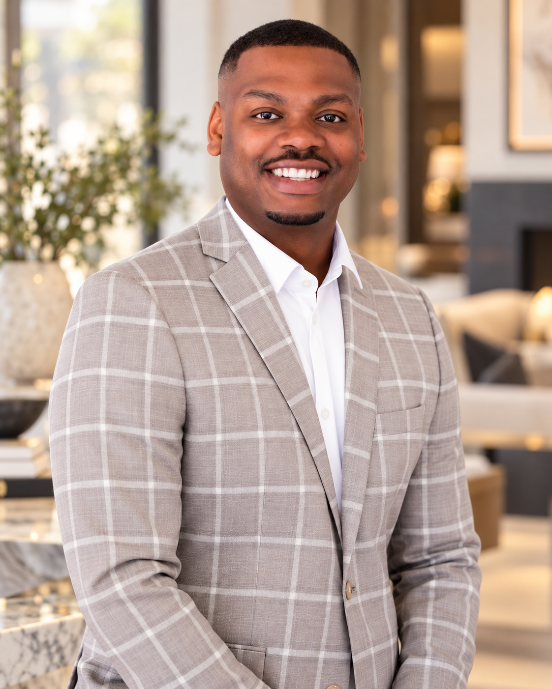 Kortez Wilson in a light checked jacket, standing in a bright interior